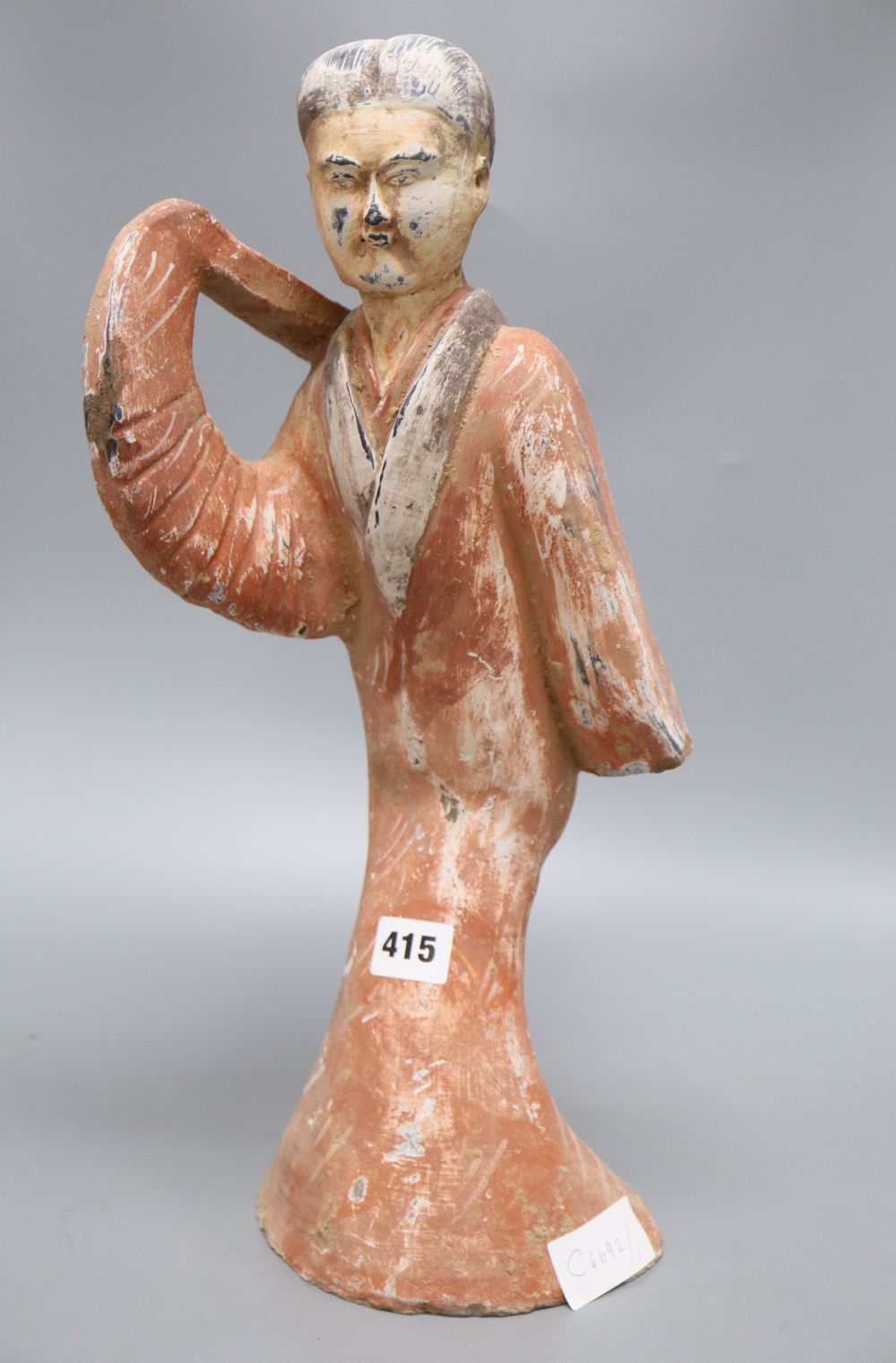 A Chinese painted pottery figure of a dancer, Han dynasty or later, height 45cm